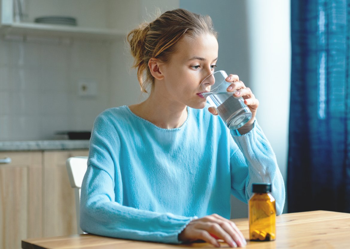 Девушка пьет таблетки